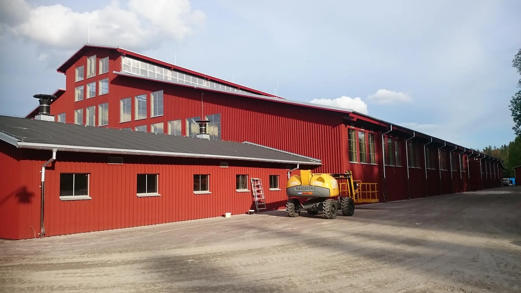 Röd industrihall med plåttak och plåtfasad